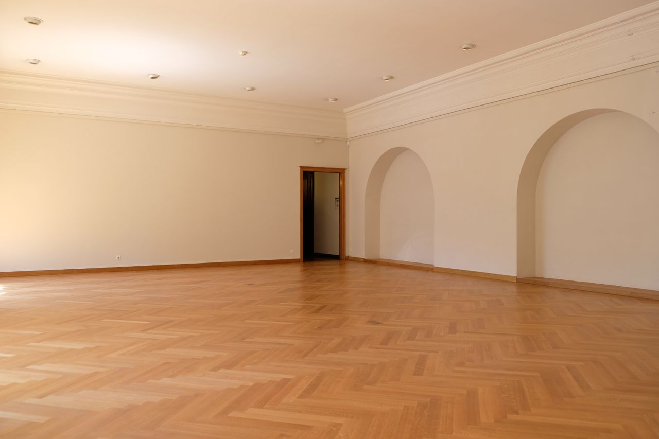 Crafting Captivating Headlines: Your awesome post title goes here A large empty room with elegant wooden flooring, arches, and natural lighting, perfect for interior design inspiration.