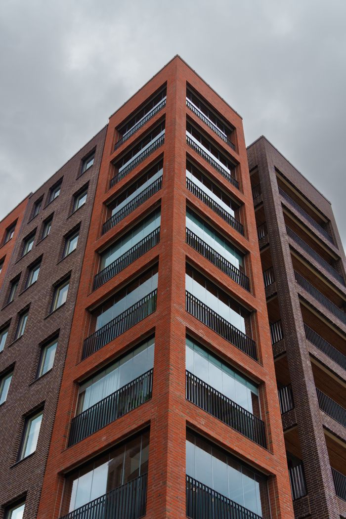 about-03 Low angle view of a modern apartment building against a grey sky.