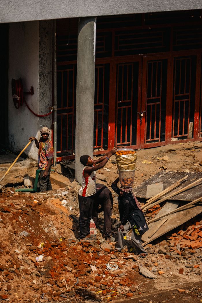 services-01 A group of construction workers engaged in manual labor on a city building site.